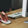 pexels-photo-392018-392018 A hand using a wireless mouse at a modern desk setup with a computer and keyboard.